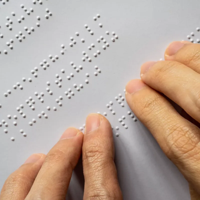 Blind person reading braille of alphabet A to Z